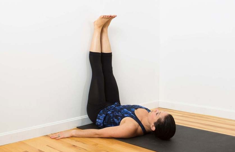 Thực hiện tư thế yoga gác chân lên tường giảm stress
